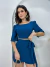 Mulher vestindo conjunto azul Duna Madri com blusa cropped de mangas curtas e saia curta com amarração lateral