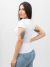 Mulher vestindo blusa babylook drapeada branco