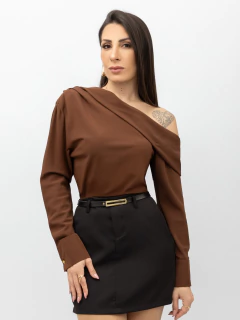 Mulher vestindo camisa marrom ombro plissado