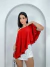 Mulher vestindo blusa bata assimétrica vermelho com um ombro à mostra