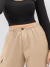 Mulher usando calça jogger cargo nude