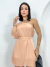 Mulher usando vestido nude curto com um ombro só e manga longa