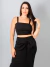 Mulher usando conjunto alfaiataria Lara preto com cropped de alças e saia midi com amarração frontal