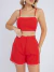 Mulher vestindo conjunto linho vermelho com top cropped de alças finas e shorts de cintura alta