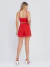 Mulher vestindo conjunto linho vermelho com top cropped de alças finas e shorts de cintura alta