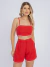 Mulher vestindo conjunto linho vermelho com top cropped de alças finas e shorts de cintura alta