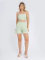 Mulher vestindo conjunto linho verde-menta com top cropped de alças finas e shorts de cintura alta
