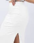 Mulher vestindo conjunto branco drapeado com top sem mangas e saia longa com fenda lateral