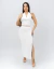 Mulher vestindo conjunto branco drapeado com top sem mangas e saia longa com fenda lateral