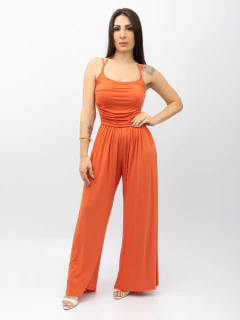 Mulher vestindo macacão drapeado terracota de alça dupla com pantalona larga