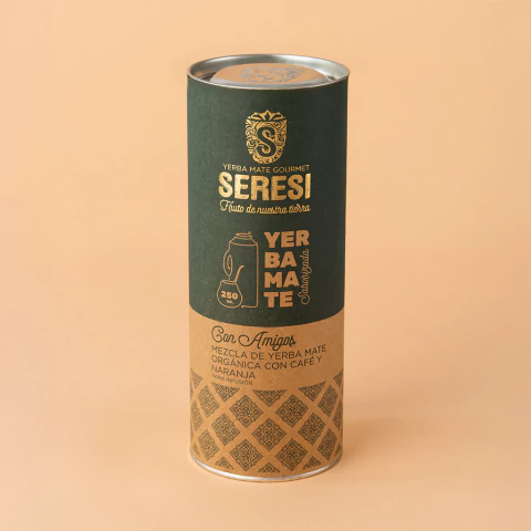 Envase tubular de Yerba Mate Gourmet orgánica SERESI Con Amigos, blend con café y naranja, diseño en tonos verde y beige con ilustración decorativa.
