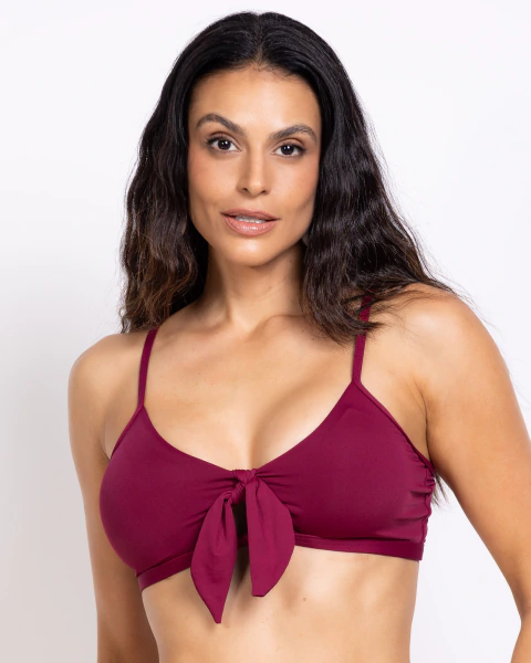 Mulher usando top biquíni camisetinha na cor amêndoa com detalhe de laço frontal CARMIN