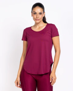 Mulher vestindo baby look dry fit poliamida com barra arredondada e manga curta carmin
