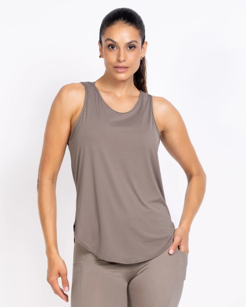 Mulher vestindo regata Guaili alongada dry fit com barra arredondada castanho