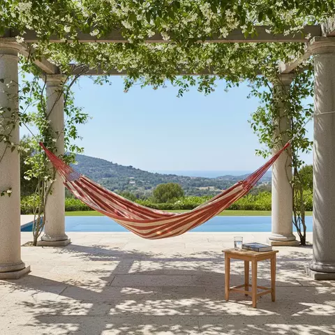 Rede de descanso Terra & Sol na cor telha com bege pendurada entre pilares sob pérgola com vista para piscina e paisagem natural
