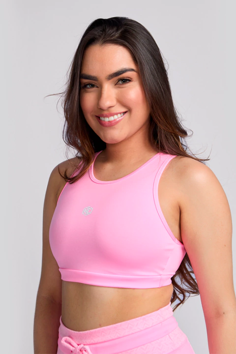 Mulher usando top esportivo cropped rosa NC Extreme para treino