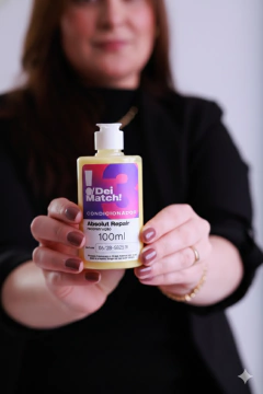 Mulher segurando condicionador fracionado Absolut Repair 100 ml da marca Dei Match