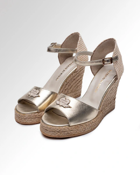 Sandalias Aline en cuero platino con plataforma de yute, diseño con pulsera y detalle decorativo en el empeine. Saverio Di Ricci
