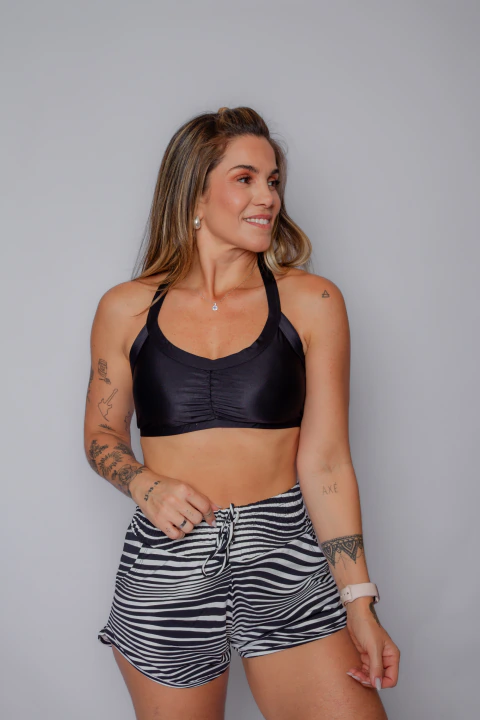 Mulher vestindo top esportivo preto e short listrado preto e branco com forro e bolso