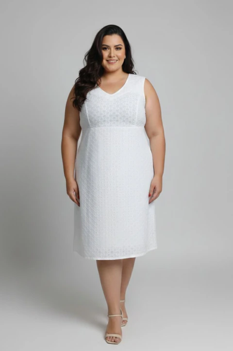Mulher plus size vestindo vestido em laise brancol com bordados brancos, com decote em V, comprimento midi sem manga.