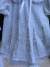 Vestido branco infantil com detalhes em renda e bordados manuais dourados, gola arredondada com acabamento em renda e mangas bufantes com laços