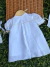 Vestido branco clássico para bebê com botões nas costas, mangas bufantes com laços e detalhes em renda