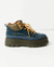 Zapato tipo zapatilla azul con hebillas doradas y suela track.