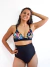 Modelo luciendo un corpiño de terciopelo Capri con estampado floral, combinado con un bikini de tiro alto en color negro.