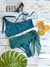 Traje de baño tipo coulotte Berenice en color verde colaless con lazo que forma parte de la prenda, con un top irregular. Incluye lentes de sol y rodajas de naranja decorativas.