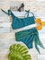 Coulotte Berenice Vedetina Verde, traje de baño verde con top y parte inferior con lazo, decorado con anteojos de sol y rodajas de naranja.