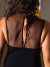 Vista posterior de una blusa negra con detalles de tul plumetti en la espalda.