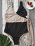 Traje de baño enterizo en tonos negro y nude, con detalle de lazo, sobre fondo de madera.