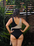 Traje de baño entero de color negro y nude, visto desde atrás, con una modelo en un entorno natural.