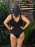 Traje de baño enterizo negro visto desde atrás, con un diseño elegante y un escote en forma de V.