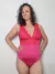 Modelo luciendo un body fucsia con puntilla roja en la parte superior, mostrando una postura confiada.