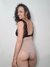Modelo posando con un body nude con puntilla negra, mostrando la espalda y parte del trasero.