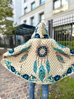 Sacón con capucha y diseño estampado de atrapasueños y flores en tonos azules y verdes, visto desde atrás con las mangas extendidas