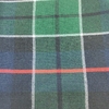 Tejido de lana Kilt en diseño de cuadros con tonos verdes, azul y una línea roja.