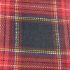 Tela de lana Kilt con diseño de cuadros en tonos rojos, negros y detalles amarillos.