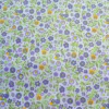 Tela de microfibra con estampado de flores pequeñas en tonos violetas, lilas y amarillos con hojas verdes sobre fondo blanco