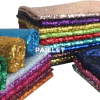 Varios rollos de tela paillete en diferentes colores, apilados y brillantes.
