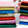 Conjunto de telas de terciopelo en diferentes colores apiladas, incluyendo rosa, verde, azul y rojo.