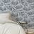 Vinilo estampado Versalles Azul en una habitación, con una cama y una lámpara de pie.