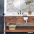 Baño moderno con vinilo estampado Versalles Gris en la pared, lavabo de madera y decoraciones minimalistas.