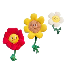 Tres tiradores de peluche para perros con forma de flores sonrientes en colores rojo, amarillo y blanco con cuerda verde en la base.