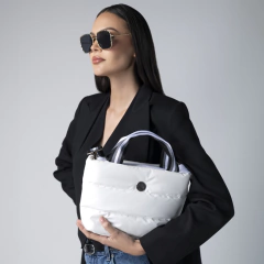 Mujer sosteniendo una bolsa DE MANO SUNDAR MINI BLANCA, luciendo gafas de sol y un atuendo elegante.