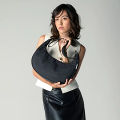 Bolsa Sundar Luna Negra Acero, modelo de mano y crossbody, sosteniéndola una mujer con un top blanco y falda negra.