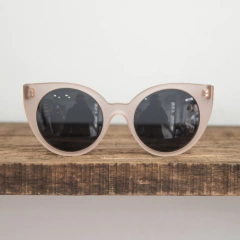 anteojos de madera (patillas) y acetato (frente) color rosa traslucido de forma redondeada con lentes polarizados modelo Vera marca Nómade (vista de frente)