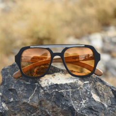 nteojos de madera (patillas), acetato (frente) color negro y aplique de acero inoxidable con lentes tintados color ambar estilo aviador vista frente | Nomade