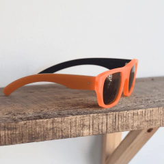 anteojos de sol de acetato color naranja fluo traslucido (frente) con patillas color naranja opaco, ambos terminación mate con lentes color gris modelo corcega pa marca Nomade vista perfil derecho